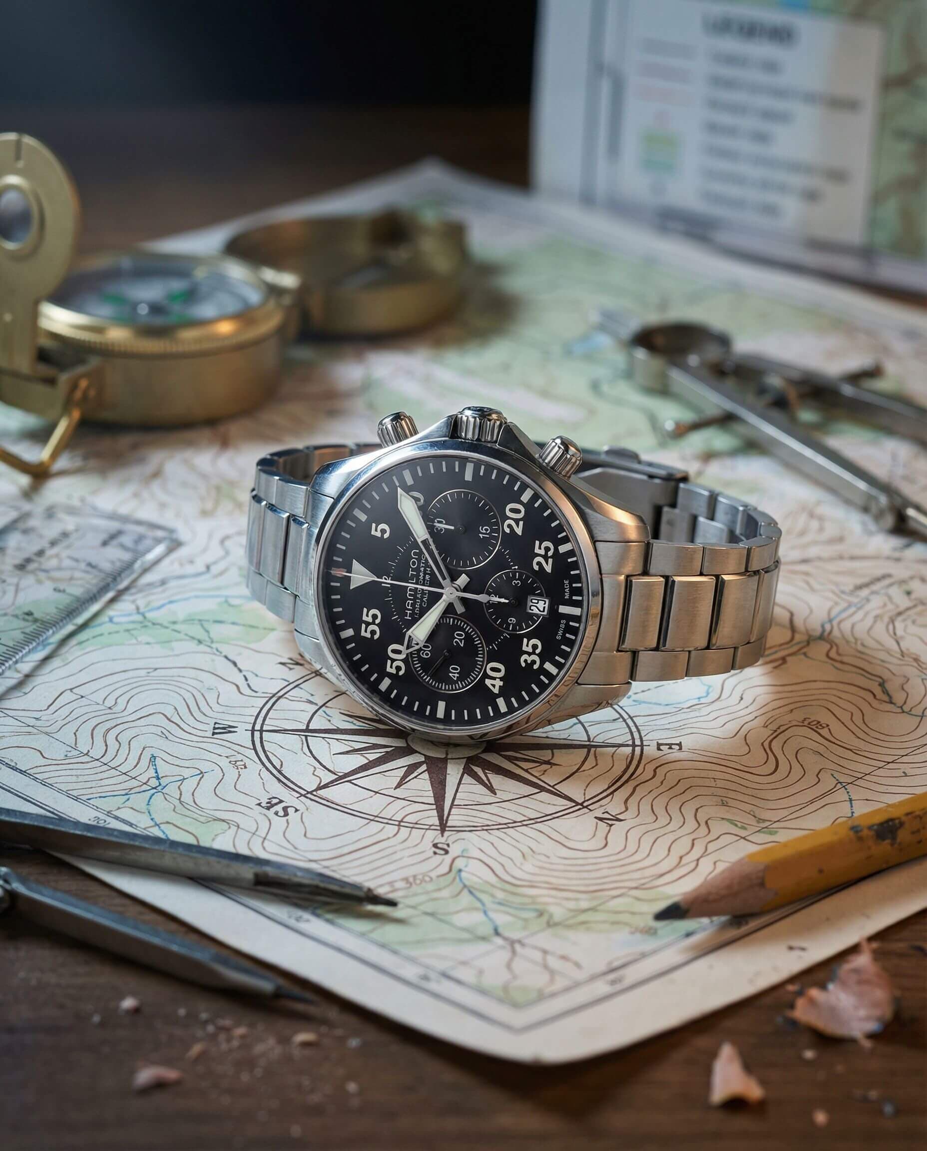 Close-up of a wristwatch on a map with drawing tools
