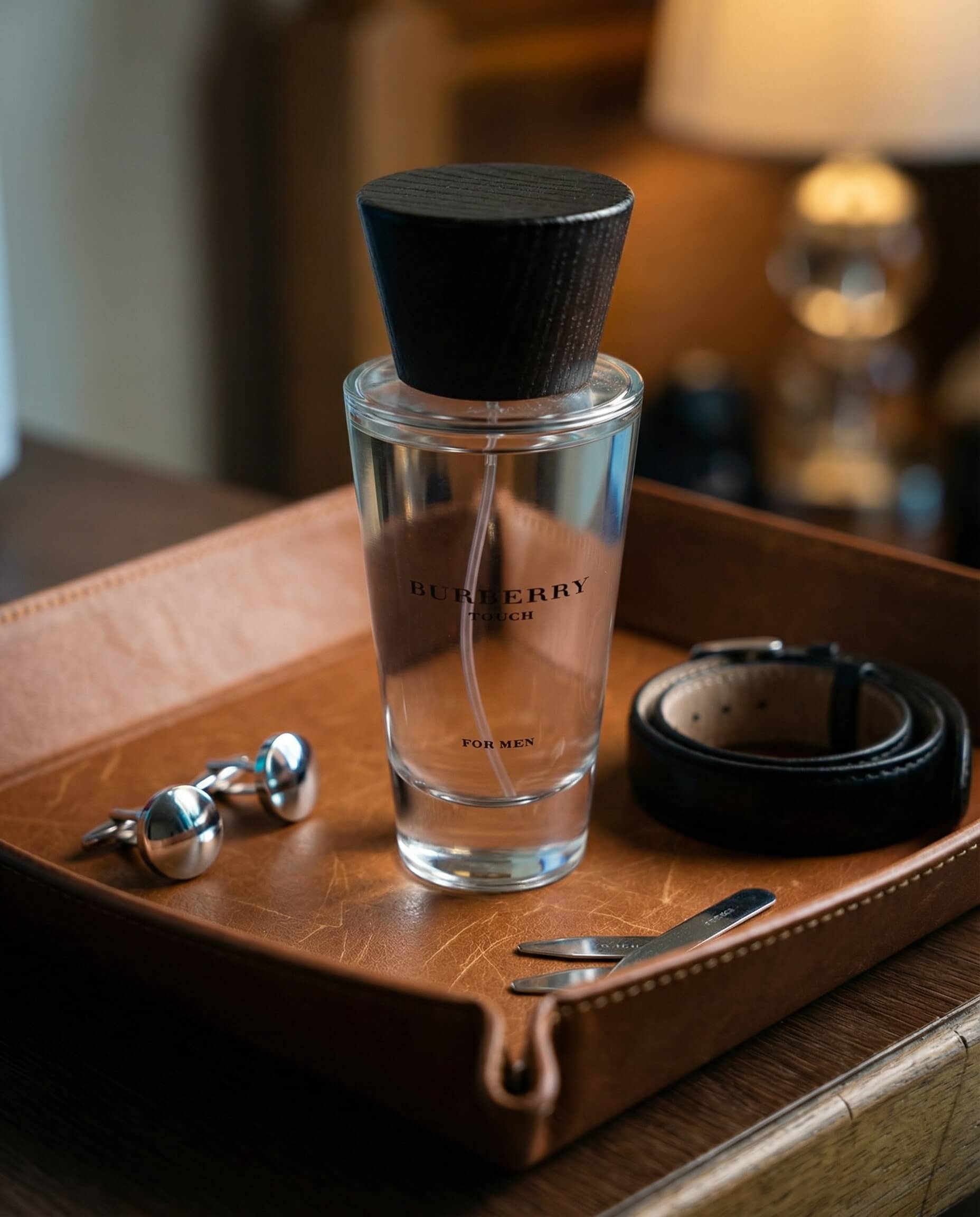 Fragrance bottle on a leather tray with grooming accessories